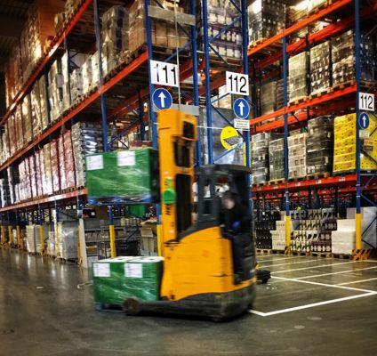 Forklift driver navigates a warehouse aisle